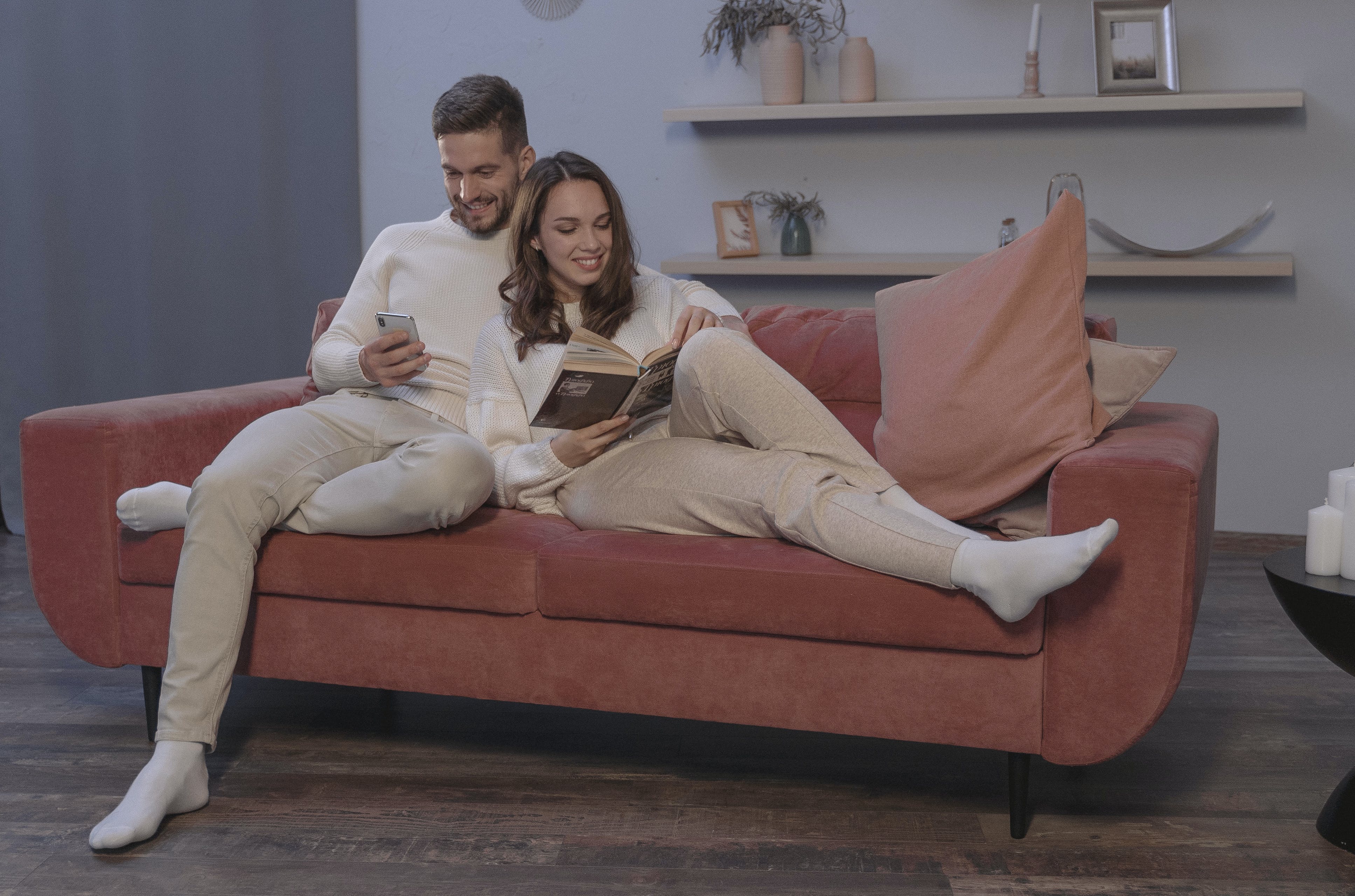 Un homme et une femme en pleine lecture sur un canapé de leur coin cocooning